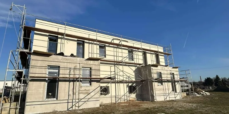 Szerkezetkész családi ház belső tere nagy panoráma ablakokkal és vakolt falakkal egy RB-Bau generálkivitelezés során.