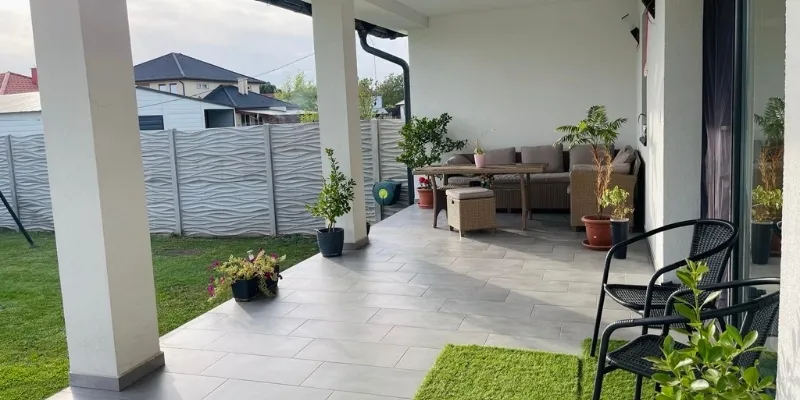 Fedett kültéri terasz és modern kerti burkolatok egy RB-Bau által épített háznál a Balaton-felvidéken.